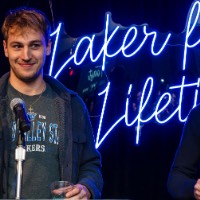 Two boys on stage holding champagne.